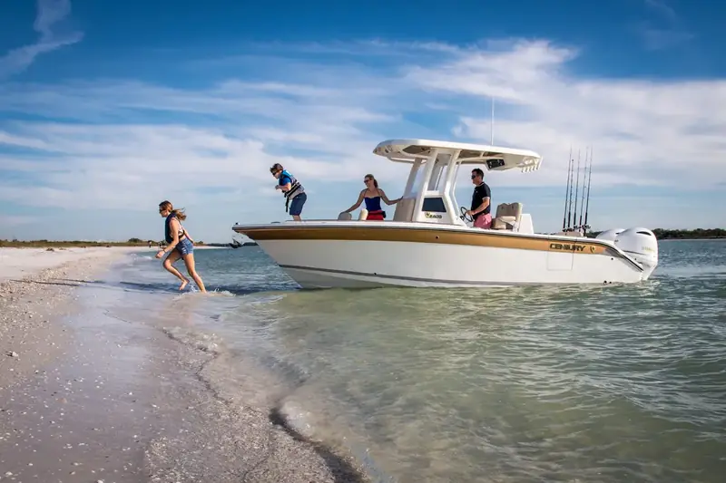 Family stepping off a center-console boat onto a sandy beach