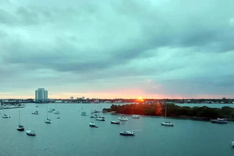 Sunset over Biscayne Bay with sailboats at anchor